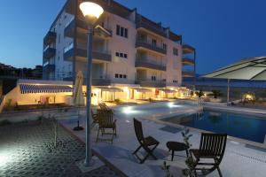 a hotel with a pool and chairs and a street light at Apartments Kamelija in Split +35 photos