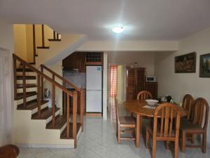 a kitchen and dining room with a table and a staircase at Coral Reef in Santa Maria