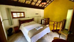 a bedroom with a bed with towels on it at Chalé Topázio in Ouro Preto