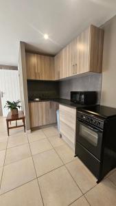 a kitchen with a black stove and wooden cabinets at Belle Vie Boutique Guesthouse in Pretoria