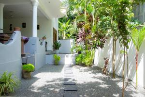a courtyard of a house with trees and plants at Angel White in Unawatuna in Unawatuna