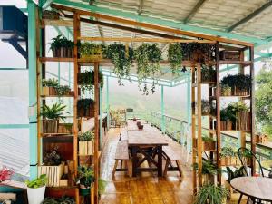 a room with a table and lots of plants at Dreamers Garden Farmstay in Hoat