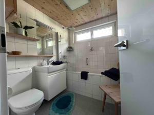 a bathroom with a toilet and a sink and a tub at Apartment Blick Schloss Tarasp - Arventraum mit Gartenspa in Scuol +63 photos
