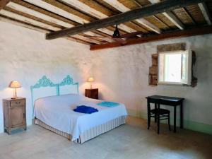 Un dormitorio con una cama y una mesa y una ventana. en La Suppinna, en Tricase