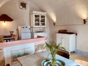 Una cocina con una mesa con un jarrón encima. en La Suppinna, en Tricase 31 fotos más