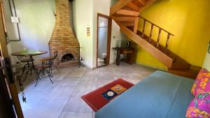 a living room with a staircase and a brick fireplace at Chalé Topázio in Ouro Preto
