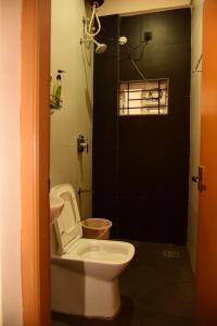 班加罗尔Studio Room in Vijayanagar的一间带卫生间和黑色门的浴室 更多13张照片