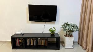 马六甲Happy Home @ Atlantis Residences [Pool View]的墙上有电视的黑色娱乐中心