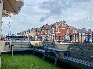 two benches sitting on the side of a building at The Libra - Adults Only B&B with guaranteed carpark in Blackpool