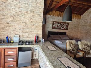 a kitchen and living room with a couch in a room at Chalé Villa Magrini in Monte Verde