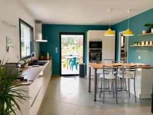 una cucina con tavolo e alcune sedie di Villa Les Vignes d Antan a Le Puy-Sainte-Réparade