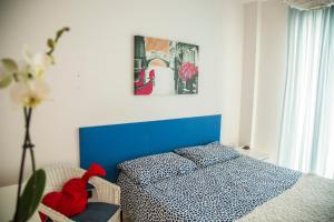 a bedroom with a blue bed with a red stuffed animal at House 30 meters from the sea with gated parking in Marina di Montenero