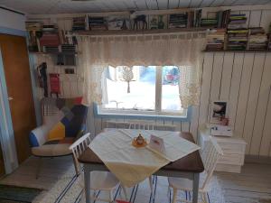 a dining room with a table and a window at Mummon Mökki in Lokka