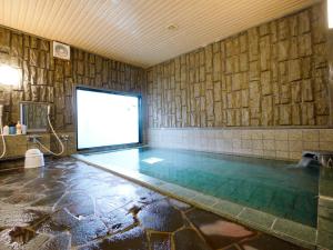 a swimming pool with a screen in a room with a wall at Hotel Route-Inn Akita Tsuchizaki in Akita
