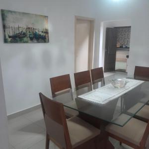 a dining room with a glass table and chairs at Secret Garden Bedroom in Cuiabá