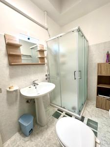 a bathroom with a shower and a toilet and a sink at EMMA Appartamento Lido Marini in Lido Marini +7 photos