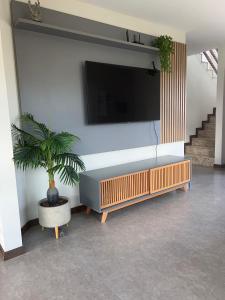 a living room with a couch and a tv on a wall at Casa Alegria in São-José-do-Ribamar +11 photos