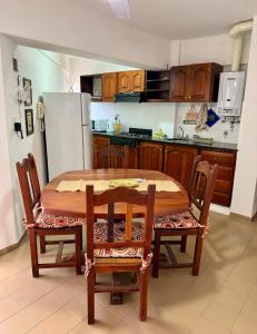 Una cocina con mesa y sillas y un refrigerador. en Plaza Nueva Departamento Céntrico en La Rioja, en La Rioja