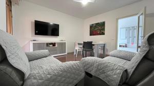 a living room with two couches and a table at Appartamento Trifoglio in Salò