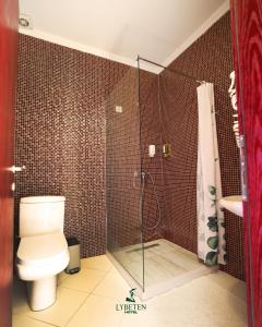 a bathroom with a toilet and a glass shower at HOTEL LYBETEN in Ferizaj