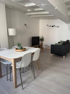 un salon avec une table et des chaises blanches dans l'établissement L'Escapade Amboisienne, à Amboise