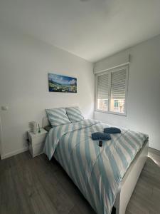 a white bedroom with a bed and a window at Ciel Bleu - 5 minutes à pied à la place de Jaude in Clermont-Ferrand