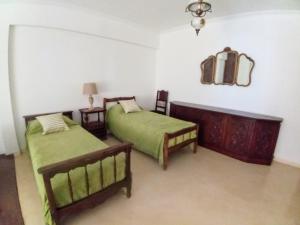 a bedroom with two beds and a mirror on the wall at Casa Francia in San Isidro