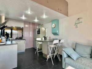 a kitchen and living room with a couch and a table at Appartement Seignosse bord de plage in Seignosse