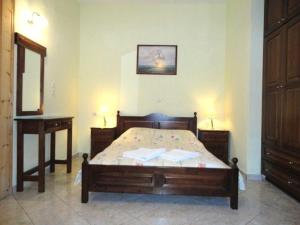 1 dormitorio con cama, mesa y espejo en Smile Stella Studios, en Skopelos Town
