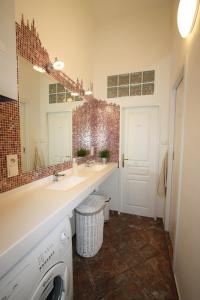 a bathroom with two sinks and a large mirror at Adam&Eva Rooms in Prague