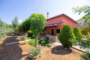 a small house with a tree in a yard at Monica's Country House in Nafplio