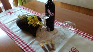 タクセンバッハにあるBiobergbauernhof Brandenauのワイン1本とグラスを用意したテーブル