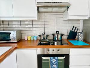 a kitchen with a stove with pots and pans on it at Protaras Cozy2bedroom Apartment in Paralimni +1 photo