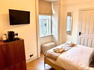 a bedroom with a bed and a flat screen tv at 'Mac' in ApartNest Auchterarder in Auchterarder