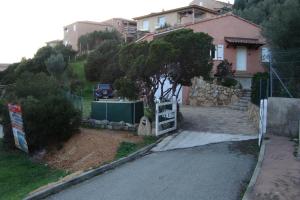a house on a hill with a fence and a driveway at Villa individuelle avec jardin in Sartène
