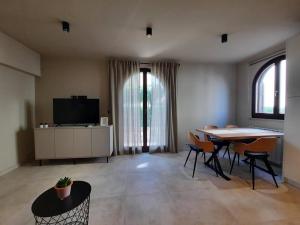 a living room with a table and chairs and a television at Apartments Alice in Rovinj