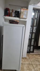 a white refrigerator in a kitchen with a shelf at Casa Margarida in Brasília