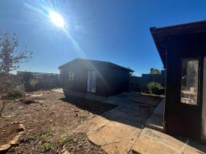 a small house with the sun shining behind it at Rincón secreto in Tomé