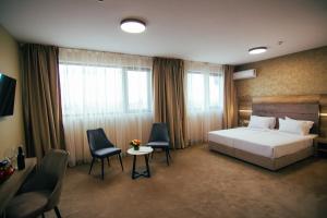 ein Hotelzimmer mit einem Bett und zwei Stühlen in der Unterkunft Hotel Via Serdika in Sofia