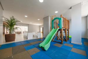 - une aire de jeux avec un toboggan vert dans une pièce dans l'établissement Apê Premium e Piscina no Bueno - Vista Bueno 2606, à Goiânia