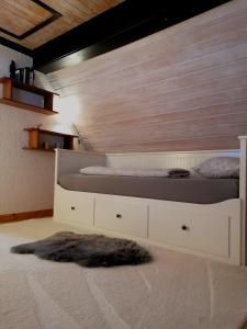 - une chambre avec 2 lits et un mur en bois dans l'établissement Ferienhaus romantisches Cottage - 2 Schlafzimmer und 2 Bäder - auf historischer Hofreite, à Gründau