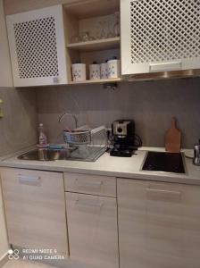 a kitchen with white cabinets and a counter top with a sink at Studio Quatro - South Pearl - Sozopol in Sozopol