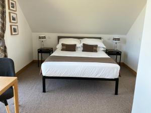 a bedroom with a large white bed with two tables at Craighall Steading B&B in Ceres