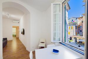 a room with a white table and a large window at San Biagio apartment in Finale Ligure