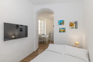a living room with a white couch and a tv at San Biagio apartment in Finale Ligure