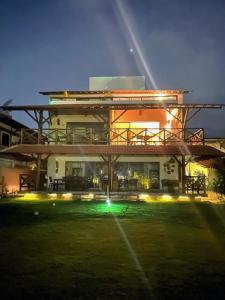 a large building with a green yard at night at Casa Turmalina in Japaratinga