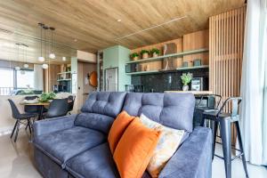 un salon avec un canapé bleu et une table dans l'établissement Apê Premium e Piscina no Bueno - Vista Bueno 2606, à Goiânia