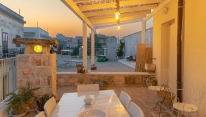 a patio with a table and chairs on a balcony at Le Casette in Gravina Luxury in Villa Castelli