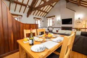 a dining room with a table with a bottle of wine at Ystumgwern Luxury Barn Conversions in Dyffryn