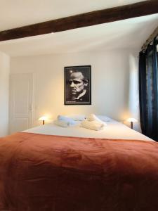 a bedroom with a large bed with a picture on the wall at Ideal longue durée centre ville in Pau